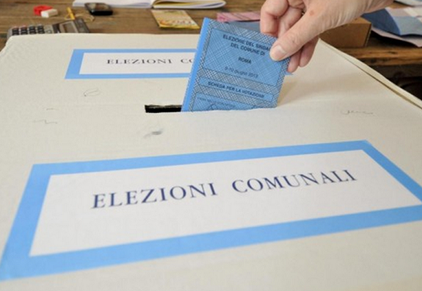 elettore al voto mentre inserisce scheda nell'urna elettorale