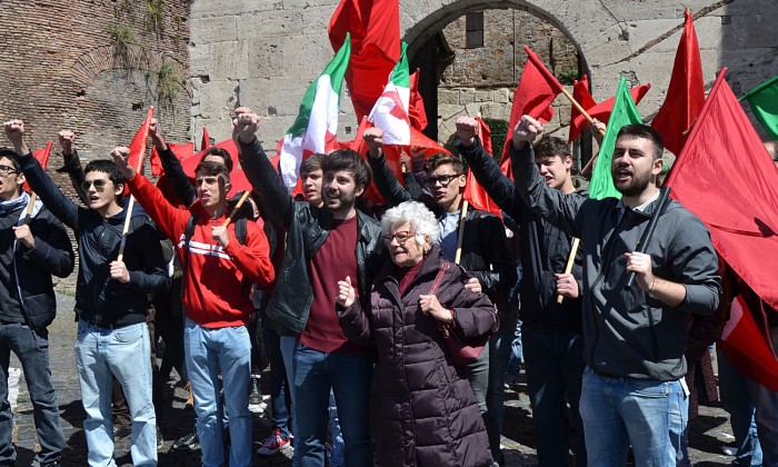comunali Roma Alessandro Mustillo, candidato a sindaco di Roma per il Partito Comunista di Marco Rizzo tra le bandiere rosse e tricolore partigiani 25 aprile pugno chiuso