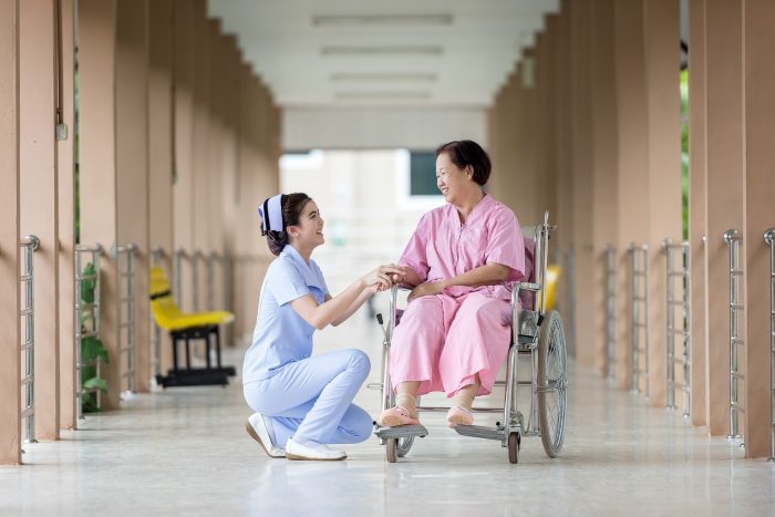 infermiera con una paziente in sedia a rotelle in ospedale, testamento biologico