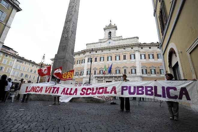 Un gruppo di manifestanti davanti a Montecitorio reggono uno striscione con scritto "lunga vita alla scuola pubblica"