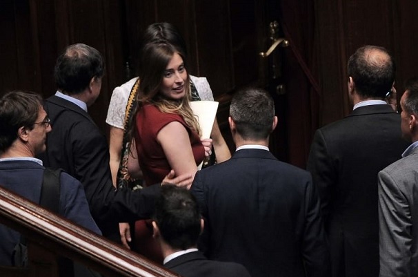 boschi in abito rosso attorniata da alcuni deputati