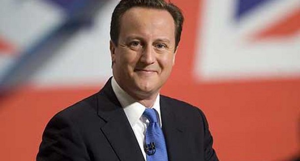 in foto il vincitore delle elezioni in gran gretagna david cameron con cravatta blu e sullo sfondo la bandiera inglese