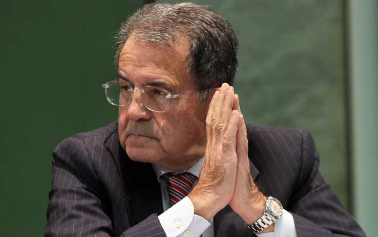 Romano Prodi con le mani giunte guarda alla sua destra