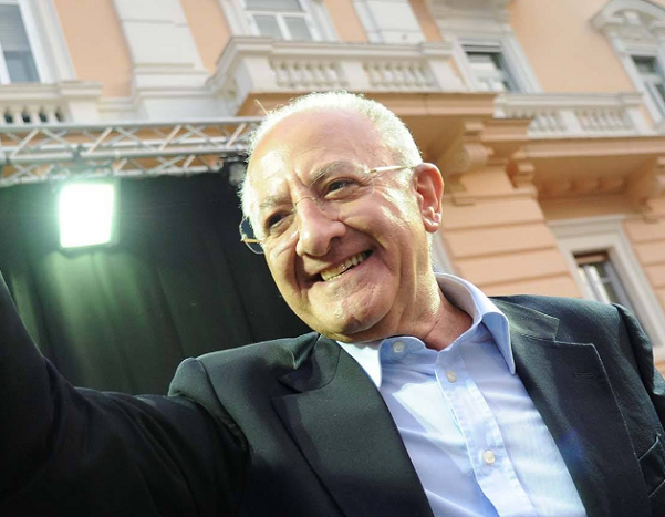 vincenzo de luca sorridente davanti ad un palco