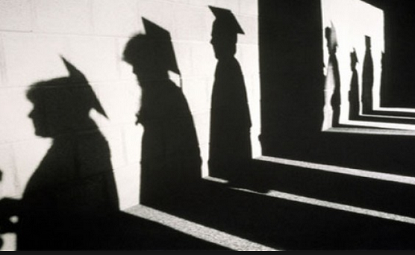 ombre di laureandi sul muro col cappello accademico