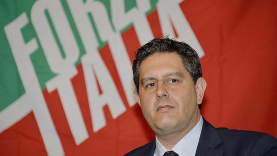 toti in primo piano con dietro logo forza italia