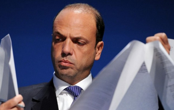 alfano intento a leggere con dei fogli di carta tra le due mani