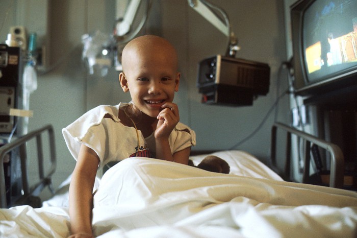 Una giovane ragazza malata di cancro sottoposta a chemioterapia in ospedale. Foto di Bill Branson, rilasciata nel pubblico dominio dal National Institutes of Health