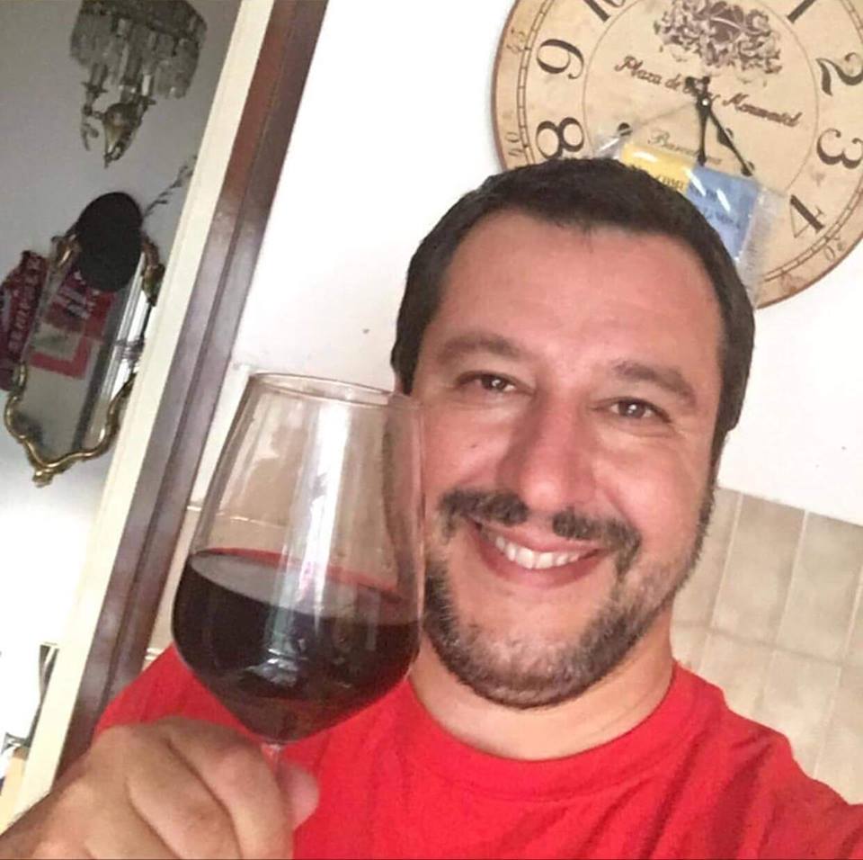 Salvini con un bicchiere di vino rosso in mano indossa una maglietta rossa