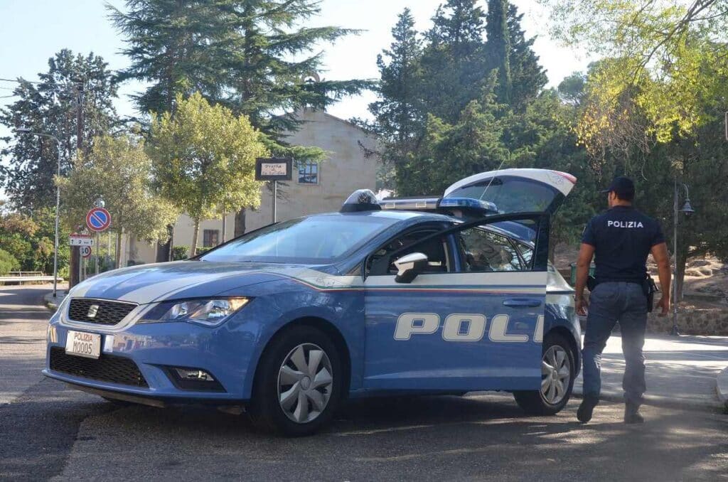 Agente della polizia di Stato vicino ad un'auto della polizia