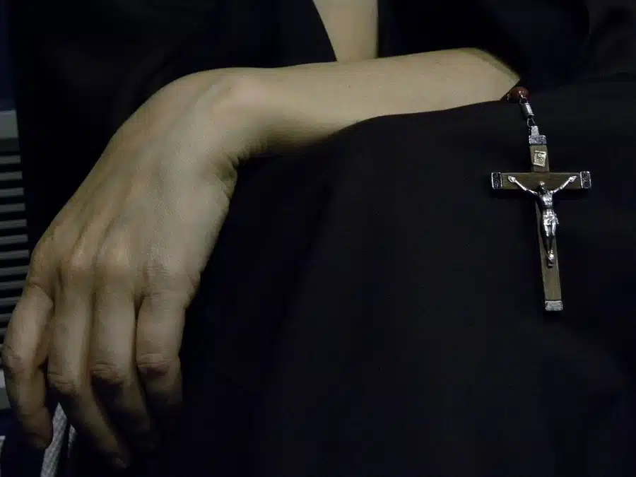 In vista l'avambraccio e la mano di una donna con in vista un rosario