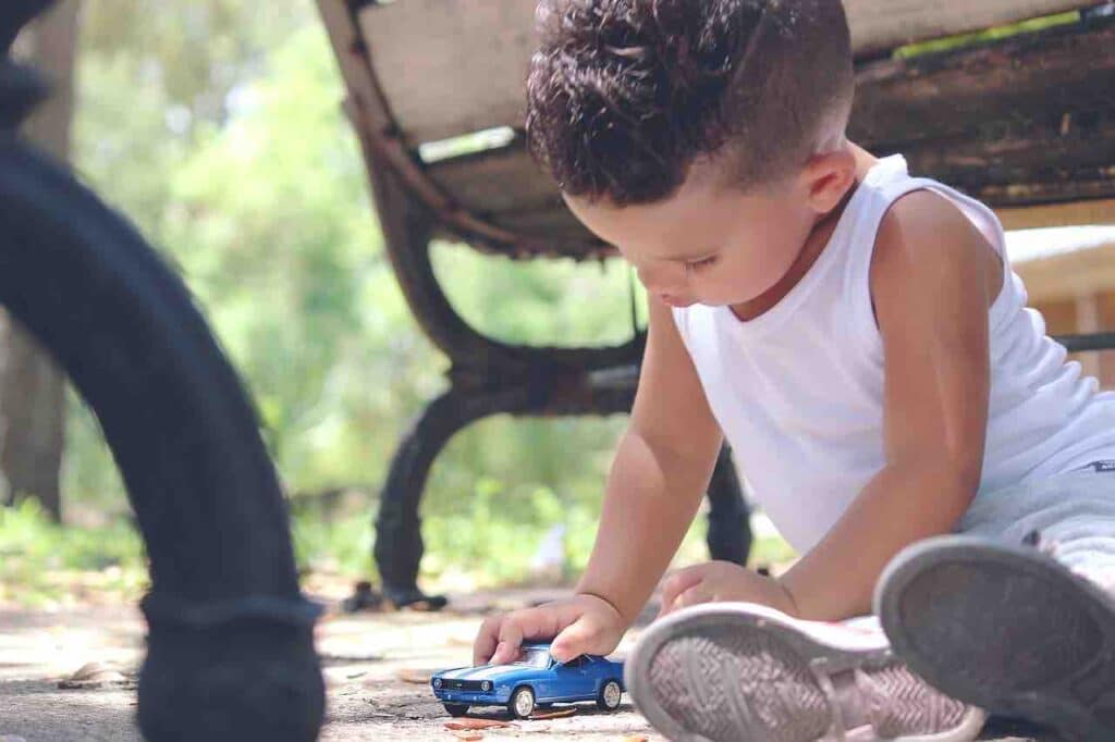 Bambino che gioca con automobile giocattolo