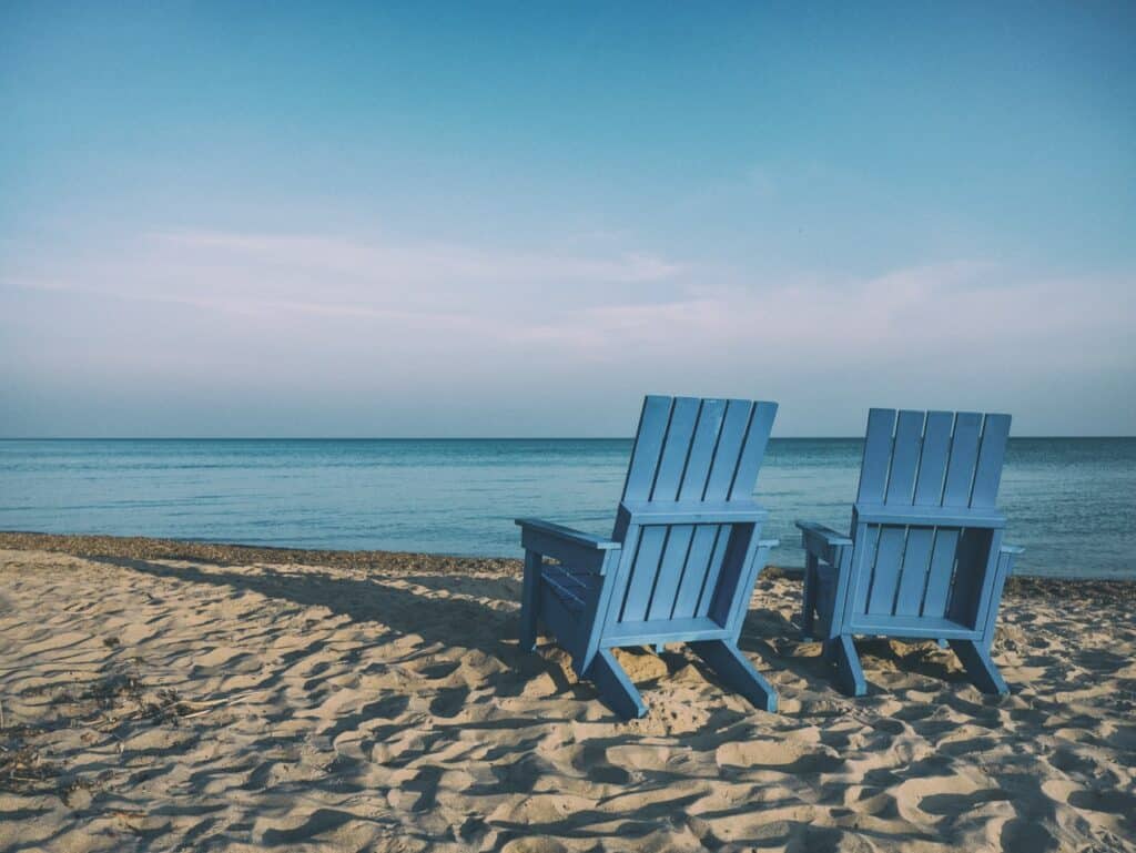 Due sedie sulla sabbia in riva al mare