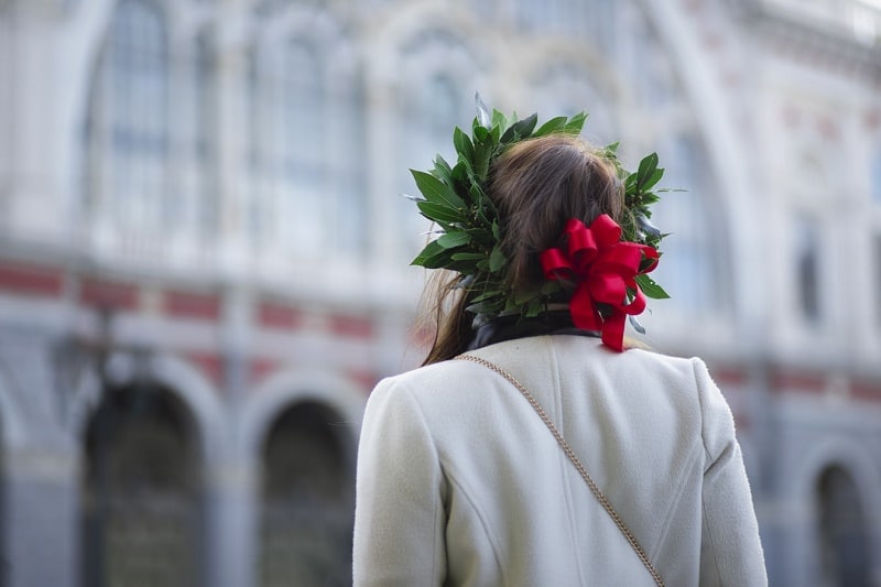 Foto di spalle ad una ragazza con in testa una corona di alloro