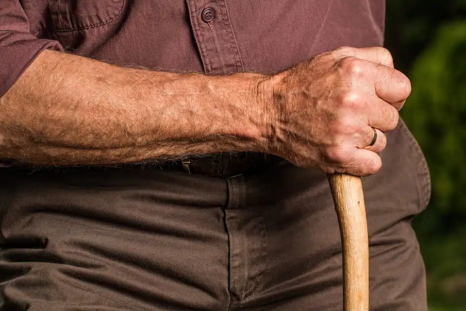 braccio maschile con un bastone nella mano destra
