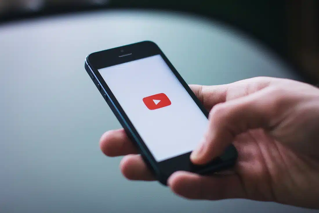 Una mano mantiene uno smartphone che ha la schermata di YouTube