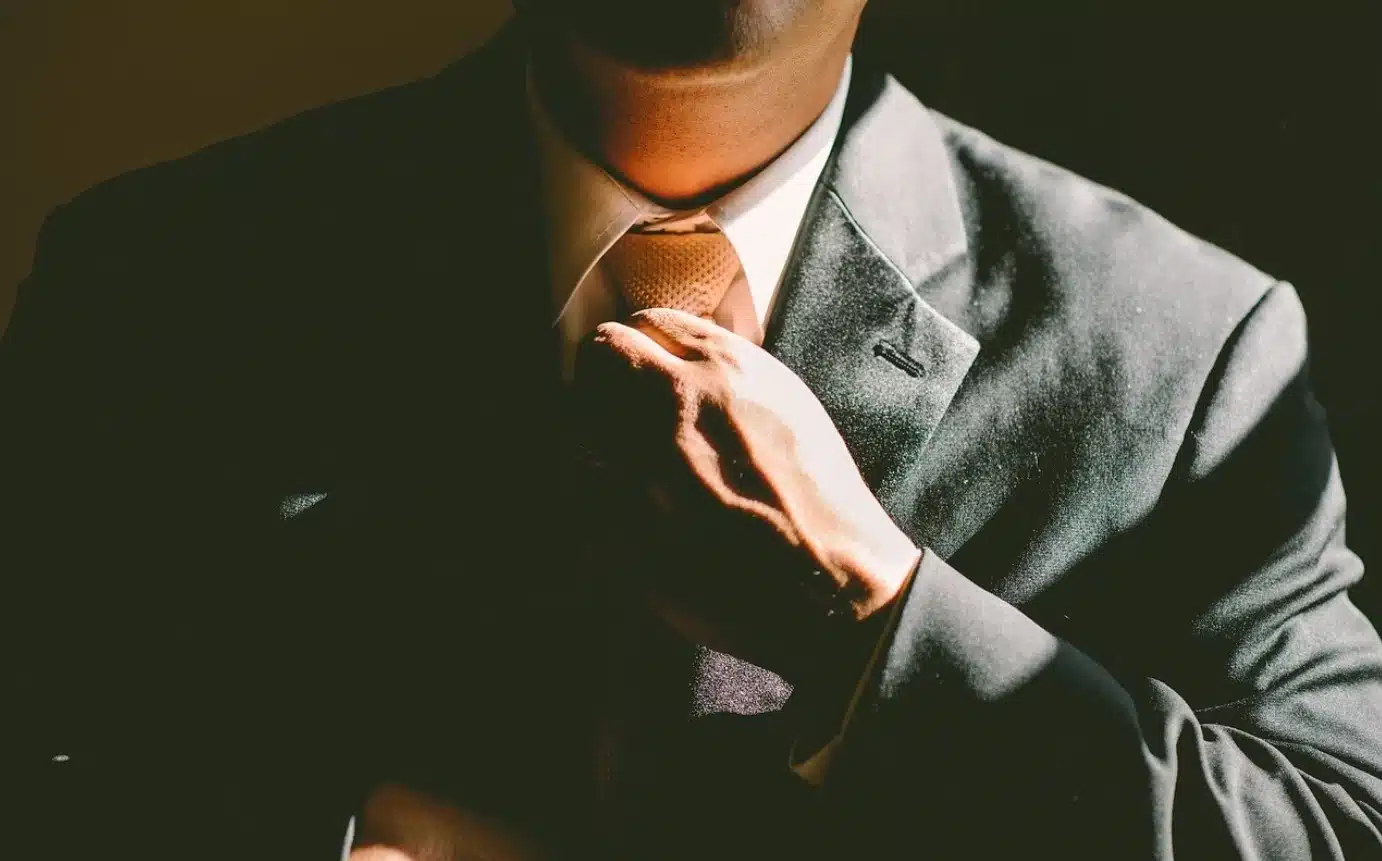Figura maschile mentre stringe il nodo della cravatta