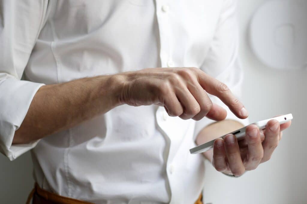 Uomo con uno telefono nel palmo di una mano