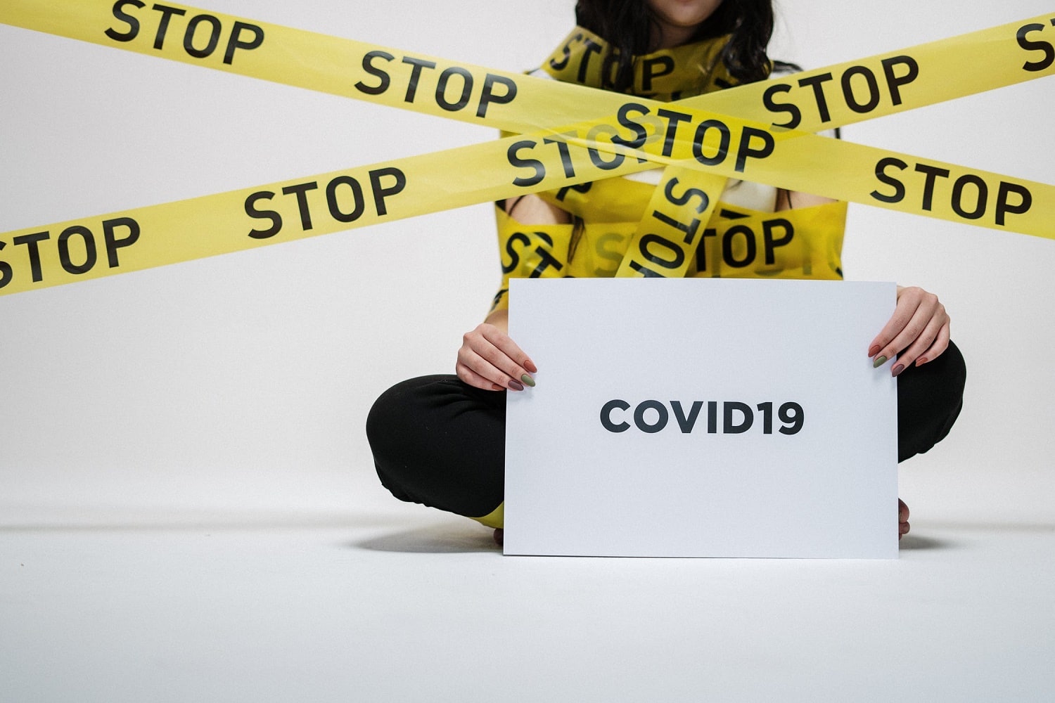 Coronavirus: una donna del nastro giallo con la scritta gialla stop ed il cartello codiv19
