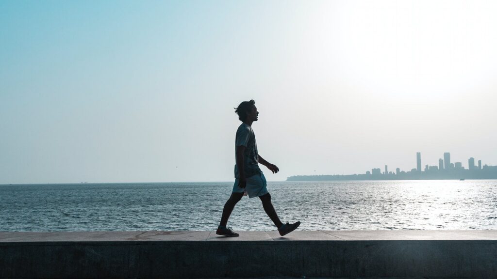 Figura di un uomo mentre passeggia avendo sullo sfondo il mare
