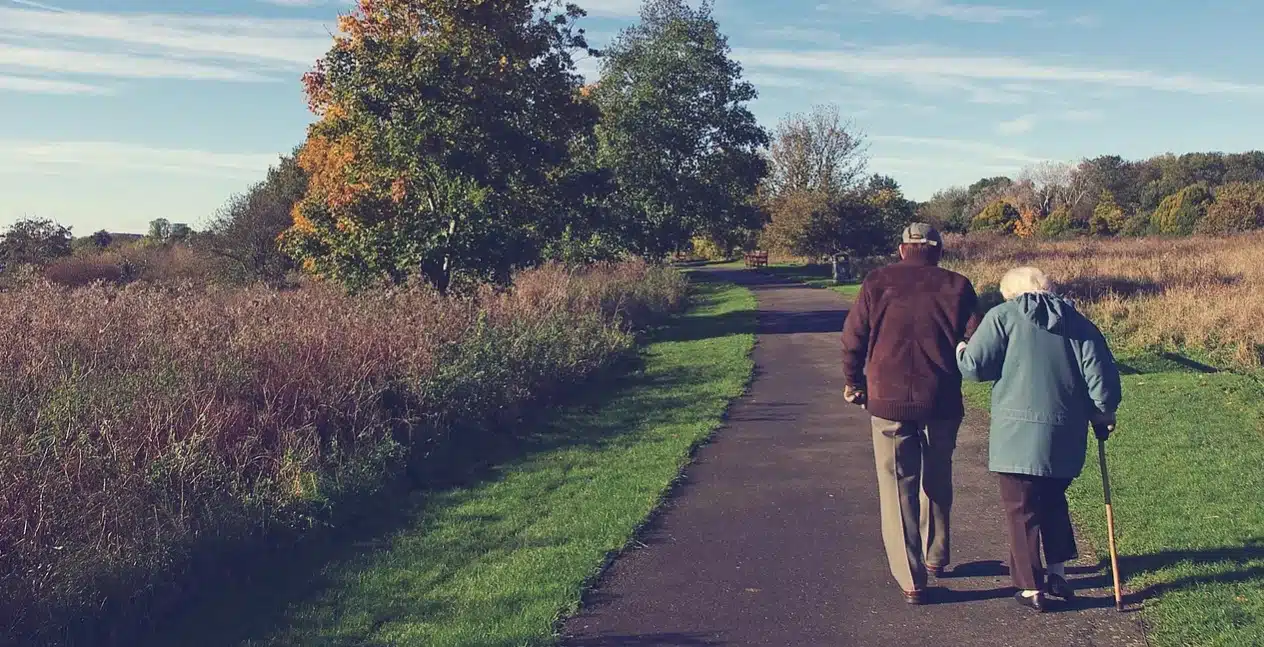 Coppia di anziani a passeggio ripresi di spalle