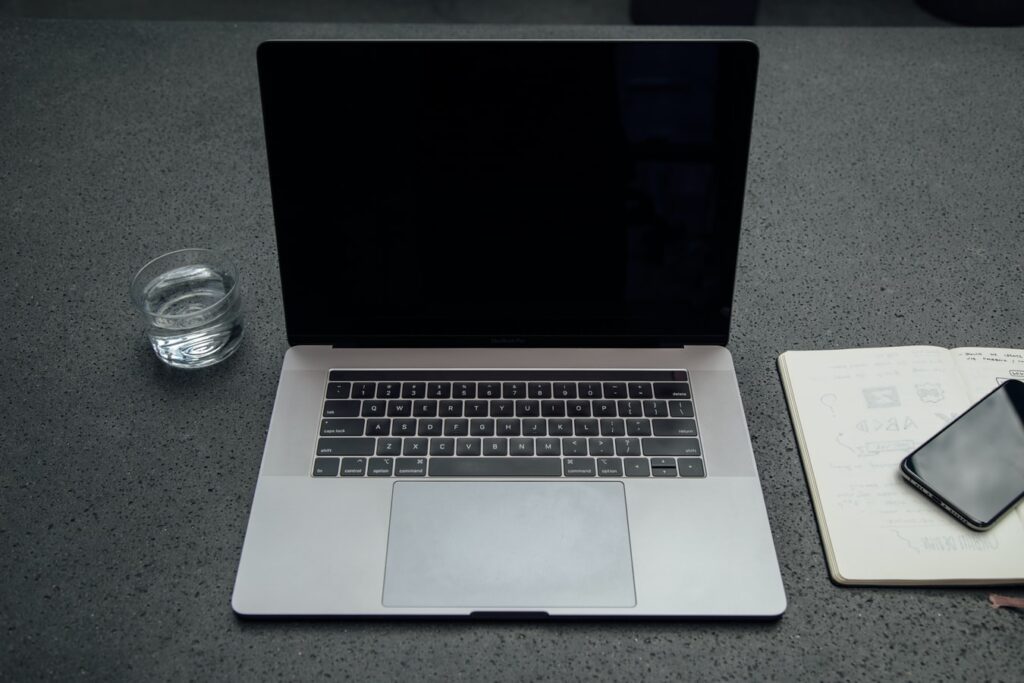 Postazione con pc bicchiere d'acqua agenda e smarthone